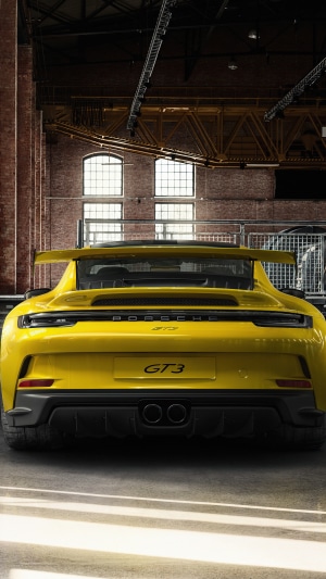 Yellow Porsche GT3 in a brick building