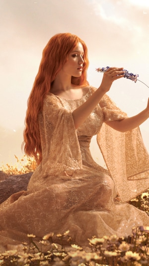 Redhead woman in a golden dress holding a flower