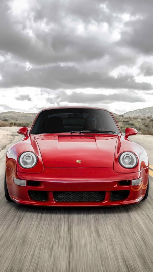 Red Porsche 911 driving on a road