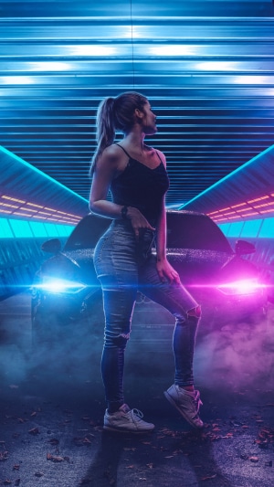 Woman in ripped jeans posing near a car with neon lights