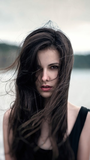 Young woman with dark hair blowing in the wind