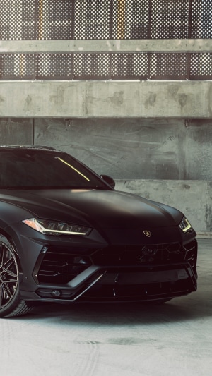 Black Lamborghini Urus parked in a concrete garage