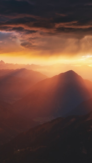 Mountains during a stormy sunset with lightning