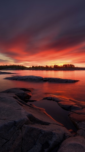 Sunset over rocky lake shore 4K