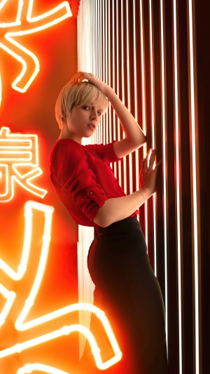 Woman with blonde hair in red top and black skirt