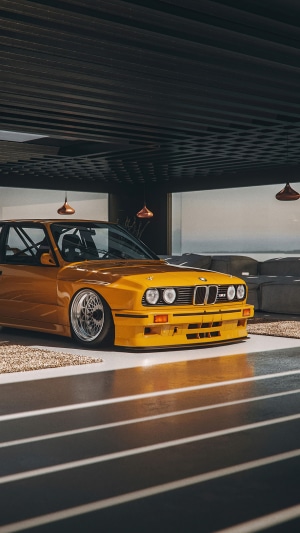Yellow BMW E30 M3 in modern garage
