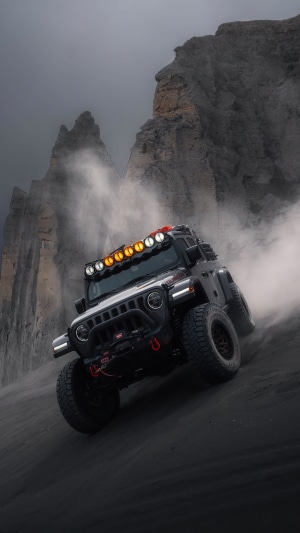 Jeep Wrangler Off-Roading in Dusty Mountain Terrain