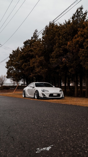 White Toyota Supra parked by trees