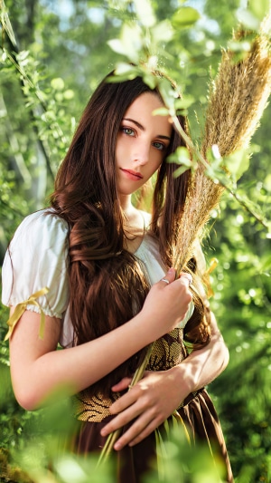 Girl with long brown hair holding reeds