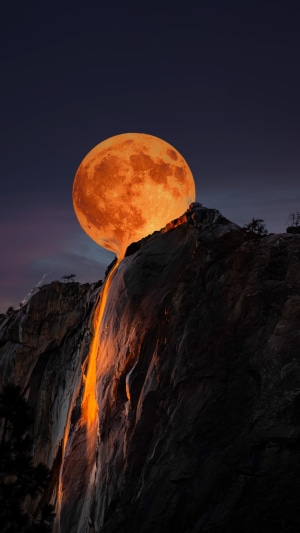Orange moon flowing like lava over a mountain