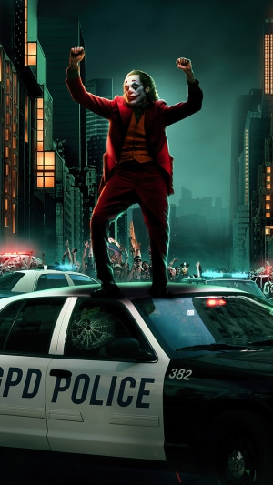 Joker standing on police car in city