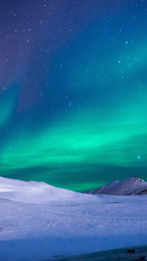 Aurora Borealis over snowy landscape