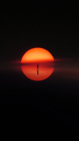 Silhouette of a person walking during sunset
