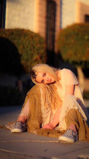 Charlotte Lawrence sitting outdoors