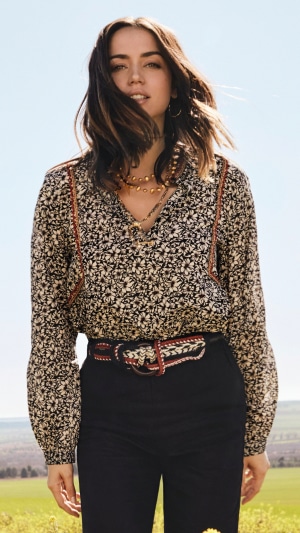 Ana de Armas in a floral blouse and black pants