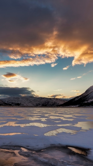Frozen lake and mountains under dramatic clouds in Norway 4K