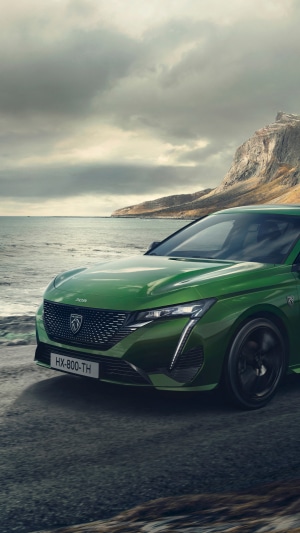 Green Peugeot 308 parked by the sea