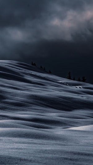 Snowy hills under dark clouds