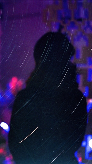 Silhouette with star trails and bokeh lights