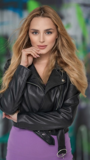Blonde model in leather jacket and purple dress