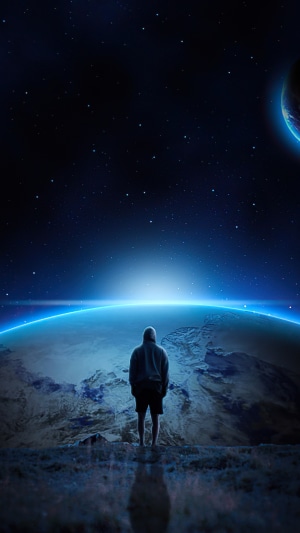 Man in hoodie looking at planet and stars
