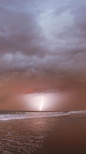 Lightning strikes the ocean during a storm