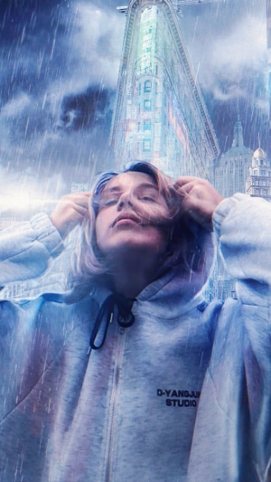 Person in hoodie in front of Flatiron Building during rain