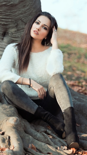 Brunette model sitting by a tree