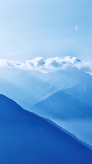 Mountains and clouds with a crescent moon in the sky