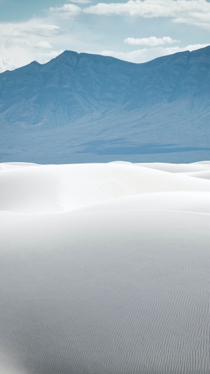 White sand dunes with mountains in the background