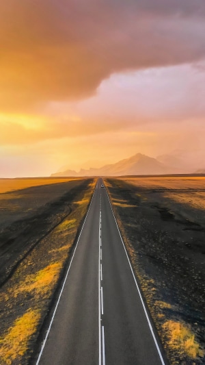 Road through a barren landscape at sunset