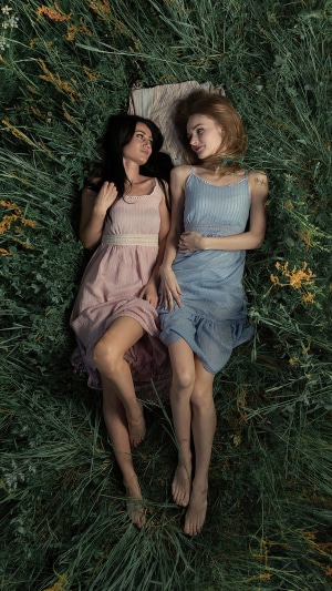 Two young women lying in grass