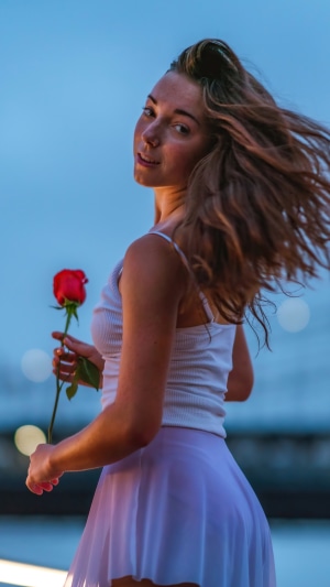Young woman holding a red rose