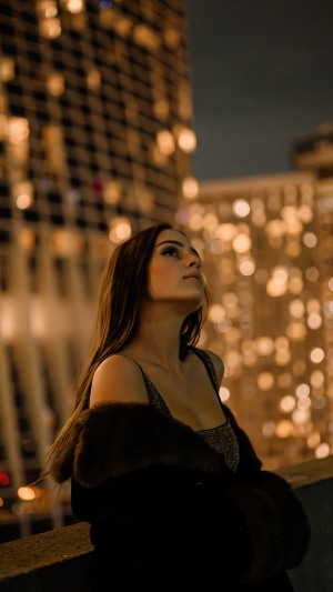 Woman looking up at city lights at night