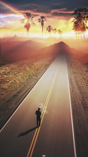 Man walking on a road with palm trees and rainbow