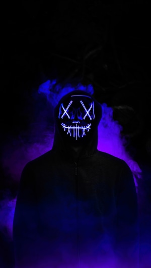 Person wearing a neon mask in smoke
