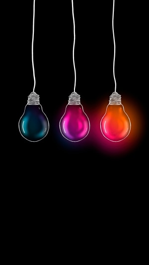 Three hanging light bulbs with colorful glow on black background
