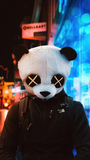 Person in Panda Mask with Glowing Eyes in Urban Night