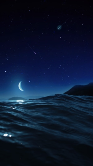 Ocean under a starry night sky with a crescent moon