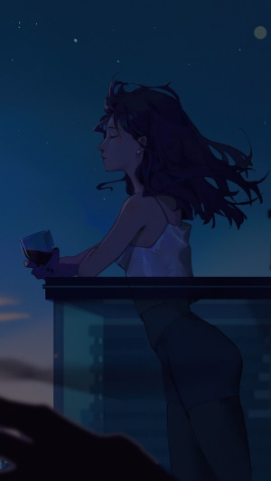Woman with wine on balcony at night