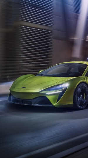 McLaren Artura driving on a city street at night