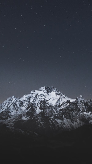 Snow-capped mountains under a starry night sky