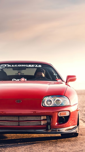 Red Toyota Supra sports car at sunset