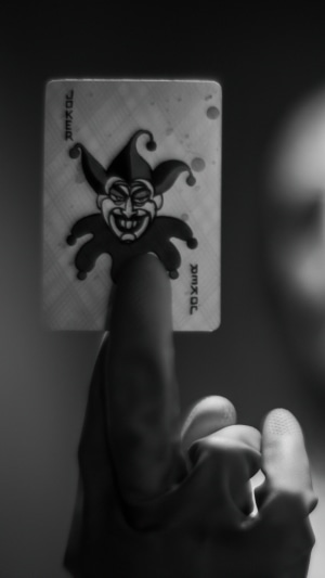 Joker card held by a hand