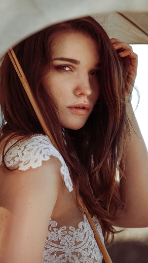 Woman with auburn hair under an umbrella