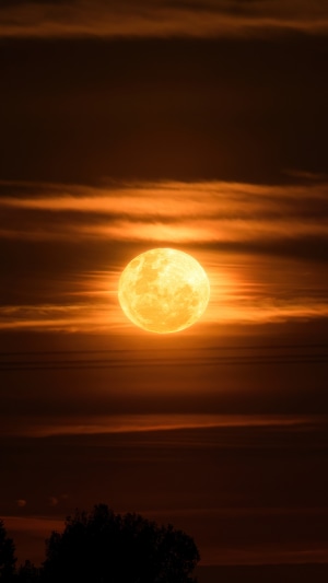 Full moon behind orange clouds