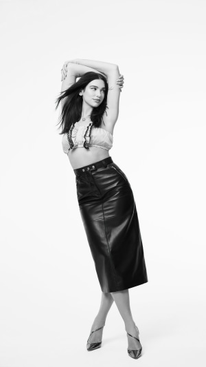 Dua Lipa in black leather skirt and crop top
