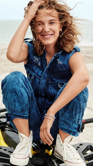 Millie Bobby Brown in Denim Jumpsuit on Beach