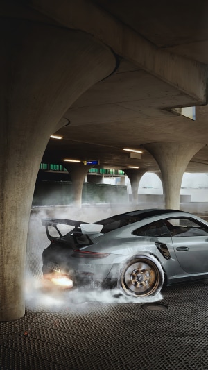 Silver Porsche 911 GT3 RS drifting with smoke