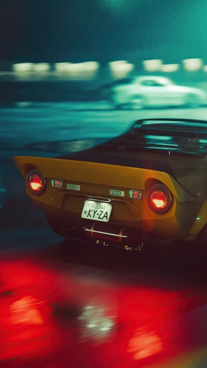 Yellow Lancia Stratos on wet road at night